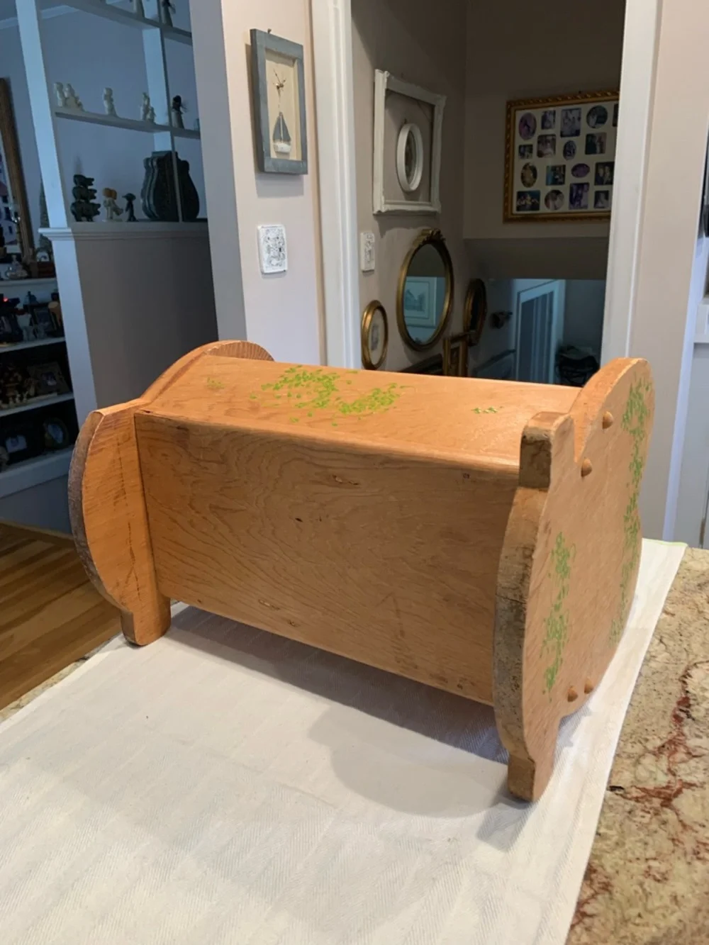 Vintage wooden doll cradle heart-shaped design painted with floral details.
